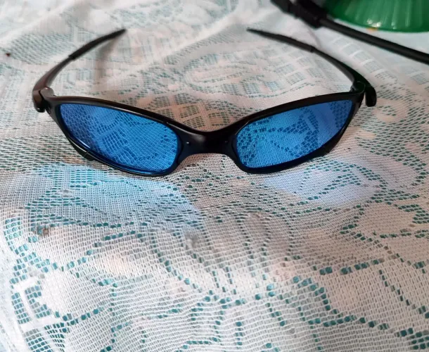 Vendo dois óculos da Oakley uma Juliet azul e uma lupa de descanso dourada.