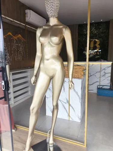 Manequim com cabeça metalizada e detalhes em pedraria.