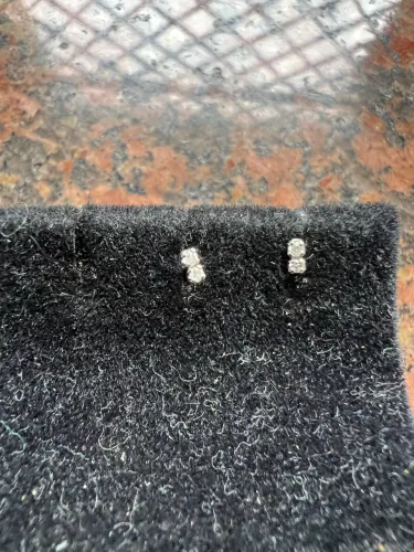Brinco infantil em ouro branco 18k com duas pedrinhas de brilhante. Possui tarraxa baby