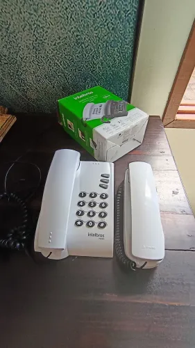 Um interfone e telefone fixo usados