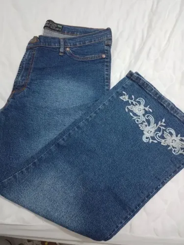Calça jeans tipo pantacourt com bordados nas pernas