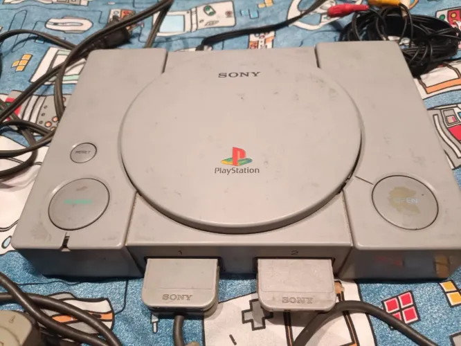 PS1 modelo SCPH-5501 FAT, com um controle original e cabos originais