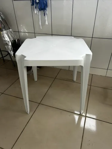 Mesa de plástico branca e banquetas pretas 
