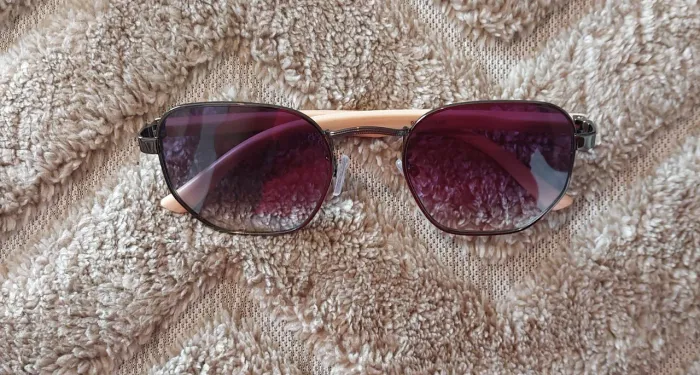 Óculos de sol armação hexagonal de metal escuro e lentes degradê em tons de lilás/rosa<br>