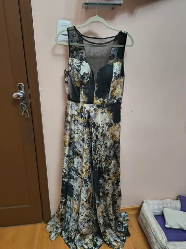 Este é um vestido longo com estampa floral em tons de preto, branco e dourado.