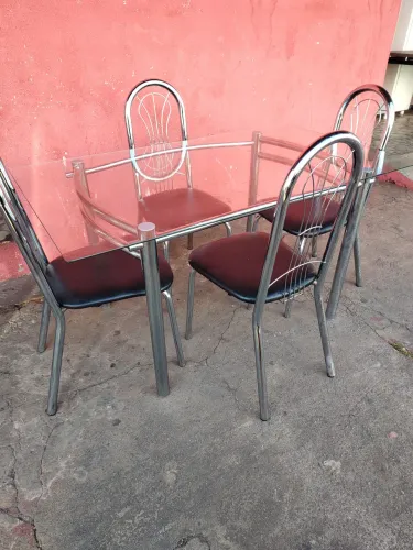 Mesa com 4 cadeiras de vidro com cadeira cromada.