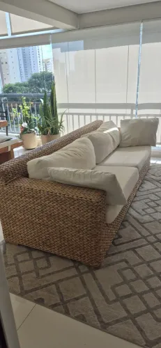 Sofa revestido fibra natural com almofadas em tecido.
