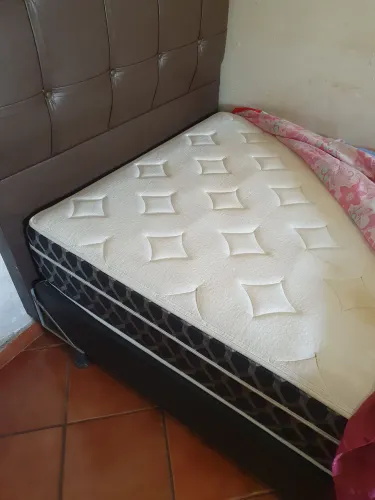 Cama Solteirao com colchão e cabeceira.
