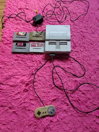 Super Nintendo com 4 fitas e um controle funcionando