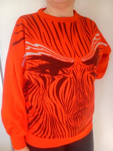 Suéter vermelho com estampa preta e prata.