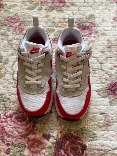 tênis infantis Nike Air Max 1 na cor branca e vermelha.