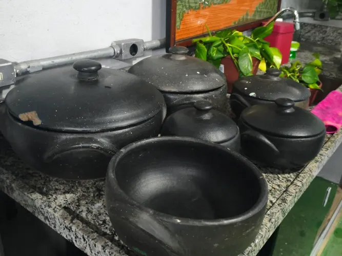 Panelas de barro e uma cafeteira grande 