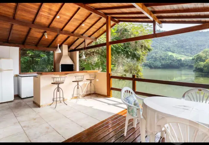 Um pequeno e ensolarado sitio, de onde se avista amplo lago.