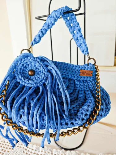 Bolsa de crochê de ombro, com alça de corrente e broche com franjas.