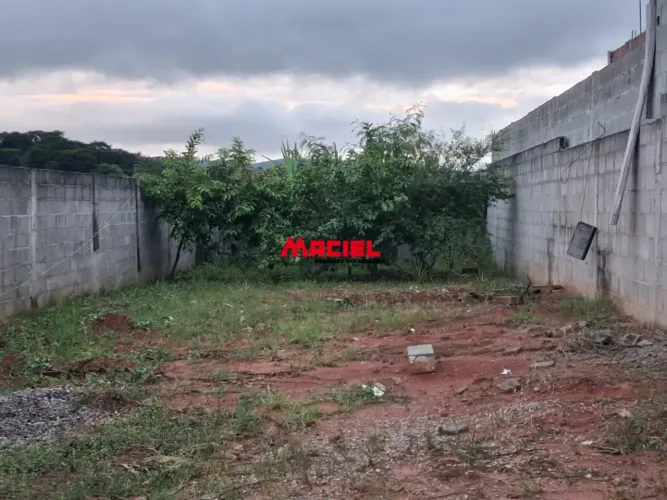 TERRENO PLANO NO BAIRRO SETVILLE, COM MUROS DE BLOCOS DE CIMENTO, PORTÃO E CALÇADA, ARVORE