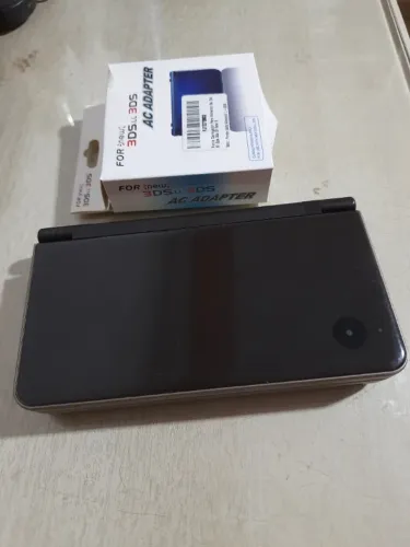 Nintendo DSi XL + carregador (detalhe tela superior)
