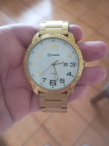 Relógio Marca Xgames, dourado, com fundo branco, novo.