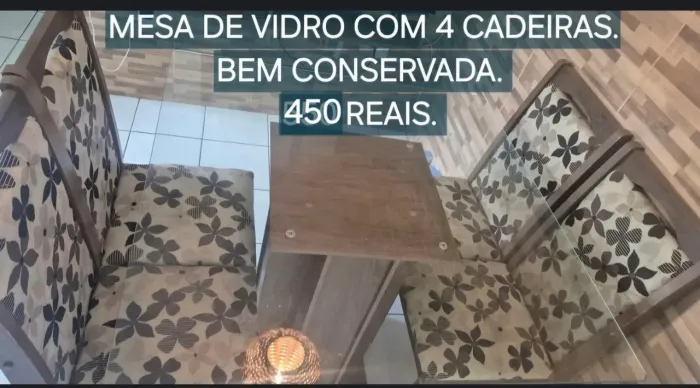 Mesa de vidro com 4 cadeiras.