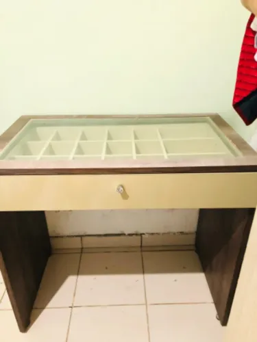 Penteadeira com divisória e tampa de vidro.