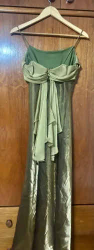 Vestido longo verde-oliva de alças finas destaca-se pelo detalhe drapeado no busto.