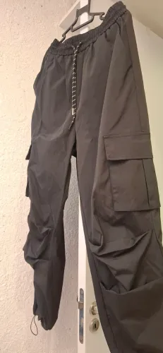 Calça cargo preta com bolsos laterais e cordão ajustável na cintura e barra.