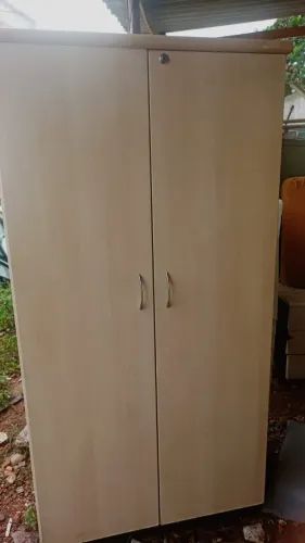 Descrição: Armário de escritório com duas portas, na cor clara (padrão madeira), ideal par