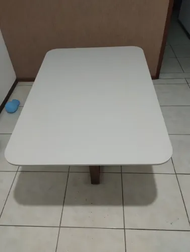 Mesa de jantar retangular com tampo de vidro.