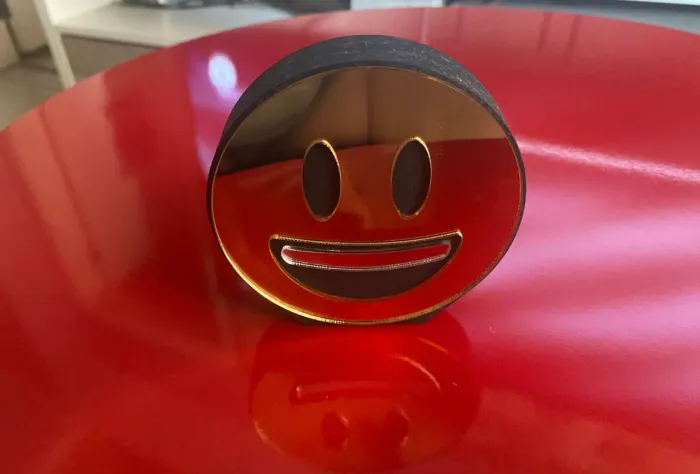 emoji sorrindo de madeira e espelhada dourado frente