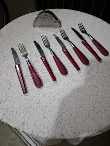 Garfos e facas,  em aço inoxidável, acompanhados de porta guardanapos em inox floral 