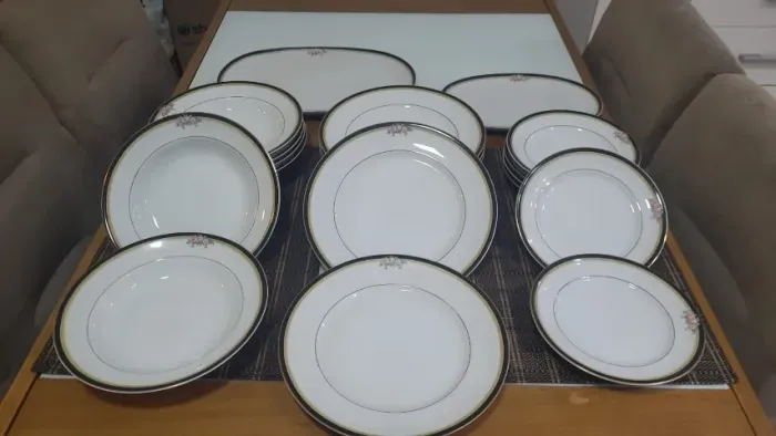 Este aparelho de jantar de porcelana Real com faixa preta e filetados a ouro. 20 peças