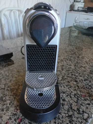 Cafeteira Nespresso cinza, usada apenas uma única vez.