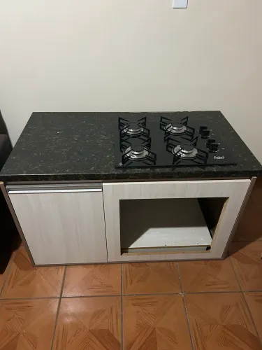 Bancada de mármore com cooktop e armário planejado