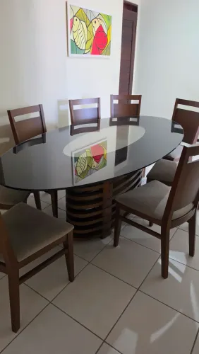 Vende-se mesa com tampo de vidro preto, acompanha 8 cadeiras estofadas.