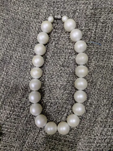 Vendo colar vintage legítimo de pérolas grandes colado no pescoço.