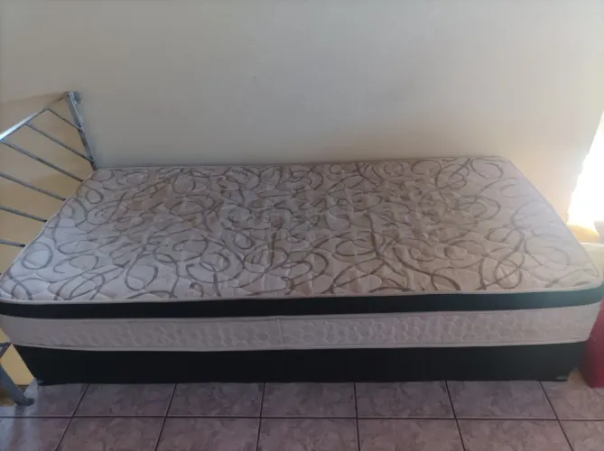 Cama box de solteiro, com uma pequena avaria no colchão