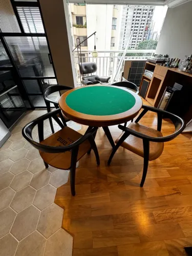 Mesa de jogos redonda com tampo verde e cadeiras