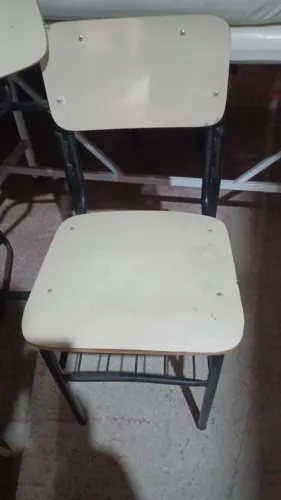 Cadeiras escolares tradicionais, com pés de ferro.