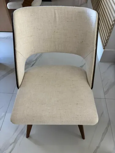 Cadeira com encosto em madeira laminada curvada e assento estofado, com design