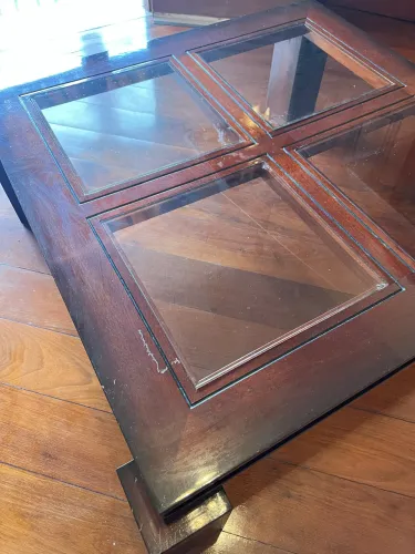 Mesa de centro em madeira maciça com tampo de vidro.