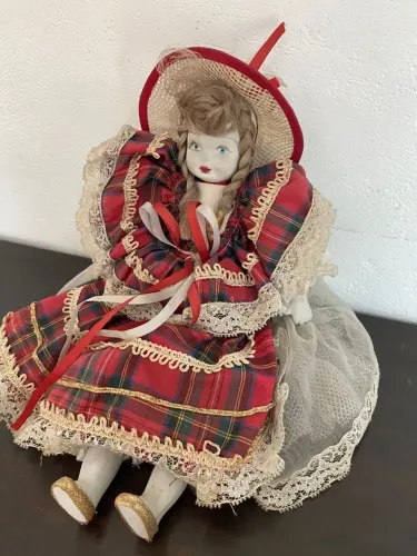 Boneca decorativa vintage com vestido xadrez de porcelana.