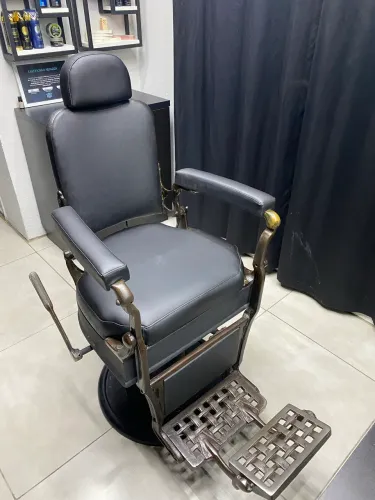 Cadeira de barbeiro antiga com a parte de tapeçaria refeita