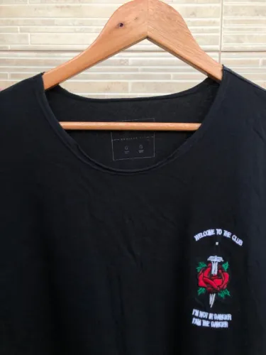 Camiseta preta com estampa de rosa e frase - G