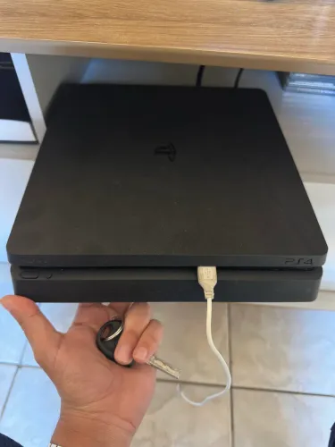 PS4 1 TB com duas manetes e jogos.