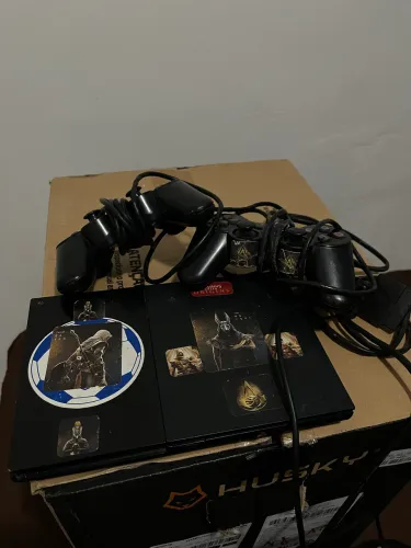 Vendo PlayStation 2 com dois controles e cabo.)