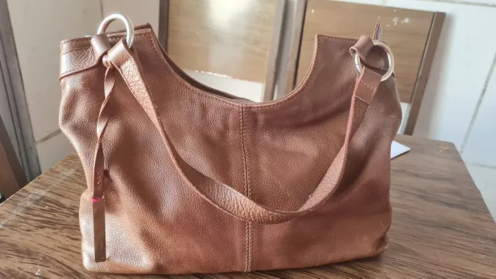 bolsa de ombro estilo Hobo/Canoa em tom marrom caramelo.