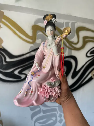 estatueta decorativa de porcelana estilo gueixa apresenta uma figura em um vestido rosa