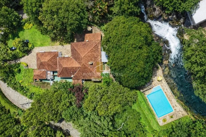 Casa ampla com 6 quartos em condomínio, lazer completo e vista para cachoeira em terreno d