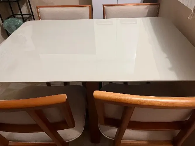 Mesa com cadeiras forradas em linho. 