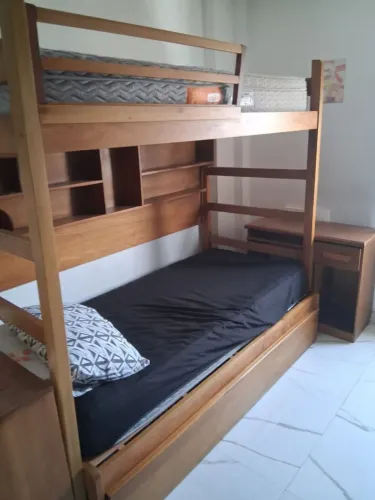 Cama tríliche, com baú e escrivaninha.