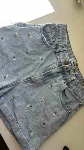 Short jeans mom cintura alta com flores bordadas